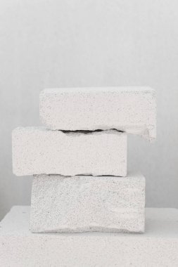 Tarafsız bir zeminde taş bloklarla dengelenmiş bileşim. Beton podyumlar, asgari fotoğraf konsepti