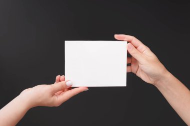 Kadın eli, koyu gri arka planda beyaz karton cilt ya da ilaç paketleri bulundurur. Hap ya da kapsüller için ambalaj. Sıhhiye ürünü modelleme, alanı kopyala