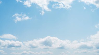 Güneşli güzel bir bahar ya da fotokopi alanı olan bir gökyüzü afişi. Mavi gökyüzündeki kabarık bulutların arasından güneş parlıyor.