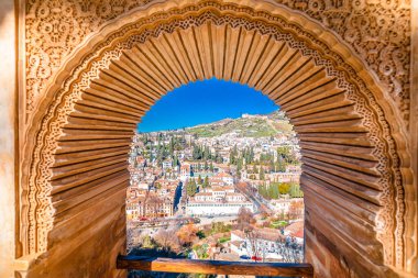 Ancient Albayzin neighbourhood of Granada view through Alhambra stone window, Andalusia region of Spain