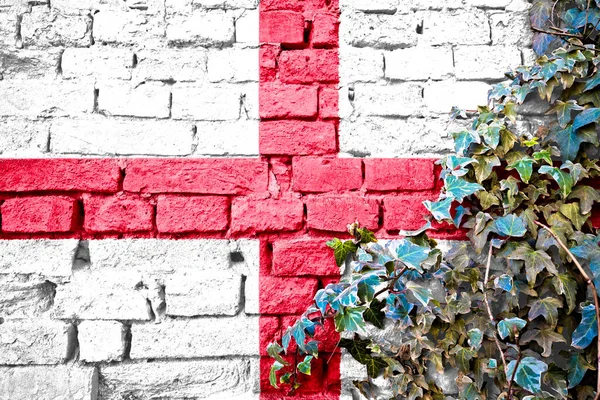 England grunge flag on brick wall with ivy plant, country symbol concept