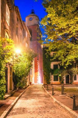 Saint Tropez village stone alley and church tower evening view, luxuty travel destination in southern France clipart