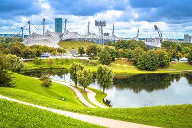 Münih Olimpiyat Stadyumu ve Olympiasee göl manzarası, önünde ördekler, Almanya 'nın başkenti Bavyera