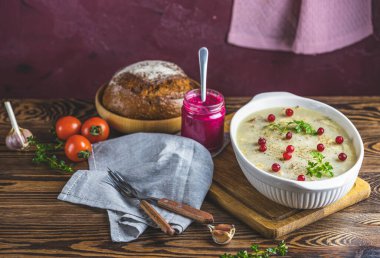 Etli lezzetli jöle, sarımsak, beyaz tabakta geleneksel Ukrayna yemeği, kızılcık, kekik, biberiye, koyu ahşap masa yüzeyinde sarımsak.