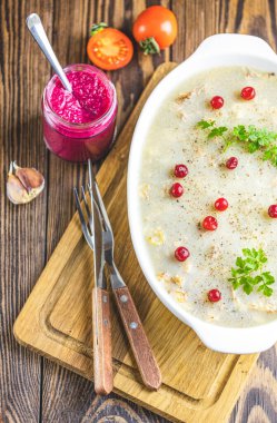 Etli lezzetli jöle, sarımsak, beyaz tabakta geleneksel Ukrayna yemeği, kızılcık, kekik, biberiye, koyu ahşap masa yüzeyinde sarımsak.