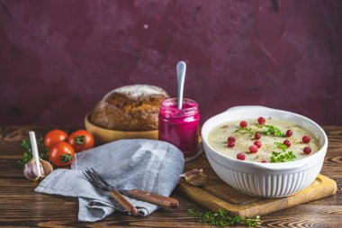 Etli lezzetli jöle, sarımsak, beyaz tabakta geleneksel Ukrayna yemeği, kızılcık, kekik, biberiye, koyu ahşap masa yüzeyinde sarımsak.