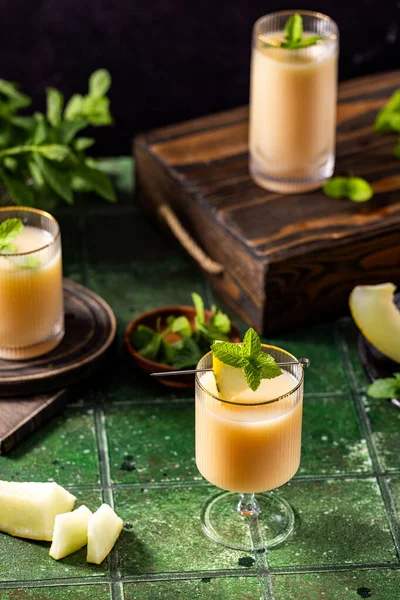 Koyu yeşil seramik kaplamalı cam kaplı kavun kokteyli, kapat. Yaz sonbahar içkileri ve alkollü kokteyller. Alkolik kokteyl ya da detoks içeceği