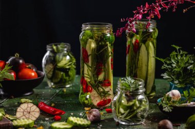 Ev yapımı sebze ve sebzeli konserve salatalık. Hasattan sonra taze salatalık turşusu. Koyu yeşil arkaplan