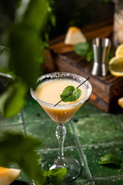 Koyu yeşil seramik zemin üzerinde nane şekerli kavun margarita kokteyli, yakın plan. Yaz sonbahar içkileri ve alkollü kokteyller. Alkolik kokteyl ya da detoks içeceği