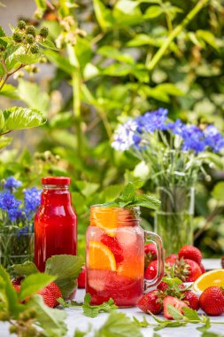 Taze çilek ve çilek suyu ile yaz kokteyli. Bahçede yemek pişirmek. Bahçede yaz tatili konsepti.
