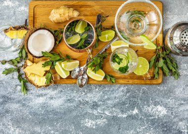 Tahta kesme tahtasındaki taze malzemelerle çeşitli yaz kokteylleri hazırlanıyor.