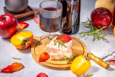 Tahtaya biberiye ile süslenmiş tereyağı dilimleri şarap ve meyvelerle