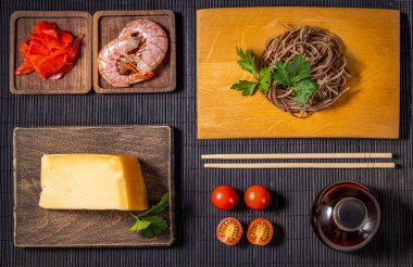 Ingredients for preparing a delicious meal with soba noodles, shrimp, cheese and other tasty ingredients clipart