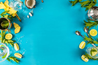 Nane, kireç, hindistan cevizi ve ananas gibi taze malzemeler canlı mavi bir zemin üzerinde düzenlenerek kokteyl hazırlığı için canlandırıcı bir sahne oluşturuyor.