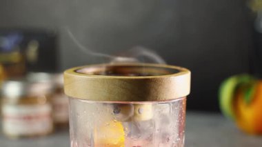 Camın içindeki dumanlı kokteyli nazikçe yakarak dikkatlice söndürmeden önce yumuşak bir duman ve sıcak bir parıltı oluşturur.