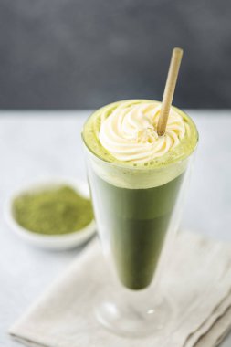 Krem şantili buzlu kibrit sütlü latte ve sağlıklı ve sürdürülebilir bir yaşam tarzını destekleyen çevre dostu bir pipetle servis edilir.