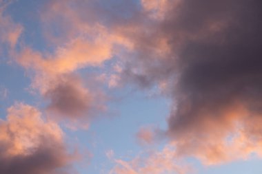 Güzel pastel renkler bulutları gün batımında boyar, akşam gökyüzünün büyüleyici bir görüntüsünü yaratır.