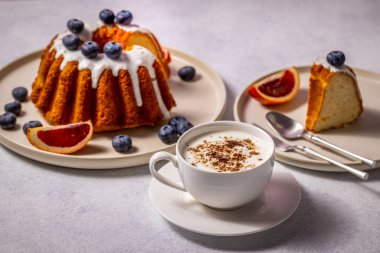 Taze gugelhupf keki, yaban mersini, kan portakalı ve bir fincan kapuçino eşliğinde harika bir kahvaltı.