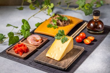 Karides, soba eriştesi, soya sosu, zencefil turşusu, vişneli domates ve maydanozlu bir parça peynir.