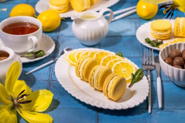 Çay ve fındıkla servis edilen lezzetli limonlu kurabiyeler canlı ve ferahlatıcı bir çay saati deneyimi yaratıyor.