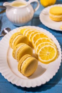 Limonlu badem kurabiyeleri taze limon dilimleri ile beyaz bir tabağa dizilmişti. Görsel olarak çekici bir tatlı sunumu oluşturuyordu.