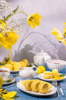 Limonlu badem kurabiyeleri, çay ve sarı laleler bu mevsimi kutlamak için mükemmel, neşeli ve davetkar bir bahar manzarası yaratır.