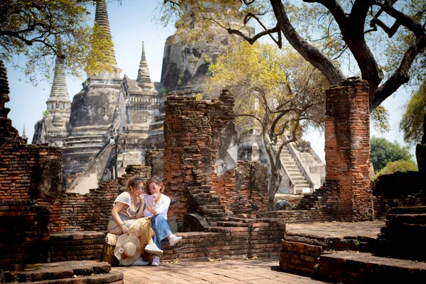 Asyalı Kadın Ellerinde Akıllı Bir Telefonla Eski Tayland Tapınağında Oturuyor — Stok fotoğraf