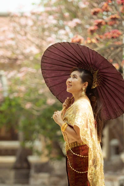 Азиатская Женщина Держит Бамбуковый Зонтик Стоящий Против Цветка Сантехники Цветущего — стоковое фото