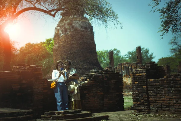 Pary Azjatyckie Kobieta Stoi Starej Świątyni Ayutthaya Patrząc Ekranie Smartfona — Zdjęcie stockowe