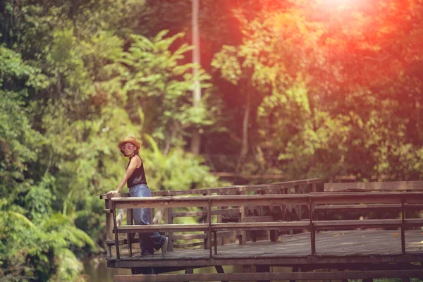 Γυναίκα Στέκεται Στο Ξύλινο Αίθριο Κατά Βαθύ Πράσινο Δάσος — Φωτογραφία Αρχείου