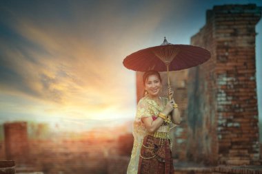 Ayutthaya Dünya Mirası 'nın unesco thailand bölgesinde bambu şemsiyesi tutan güzel Asyalı kadın eski tapınağın karşısında duruyor. 