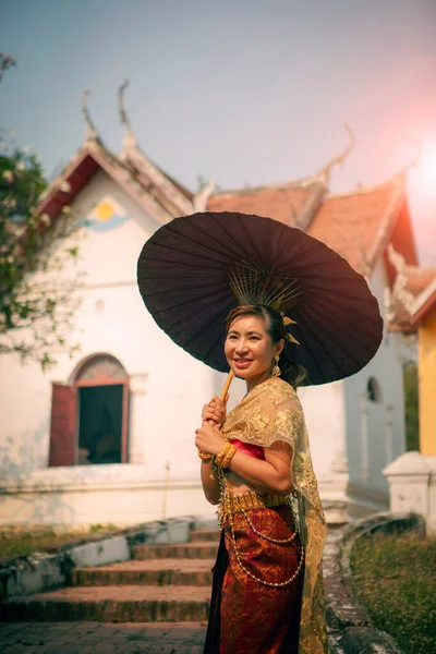 タイのユネスコ世界遺産に登録されているアユタヤの古い寺院の前に竹の傘を持ったアジアの女性 — ストック写真