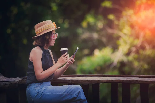Bela Mulher Ler Mensagem Telefone Inteligente Segurando Xícara Café Sentado — Fotografia de Stock