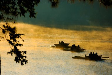 Sabahları Tayland 'ın kuzeyinde Mae Hong Gölü' nde çene çalarken.