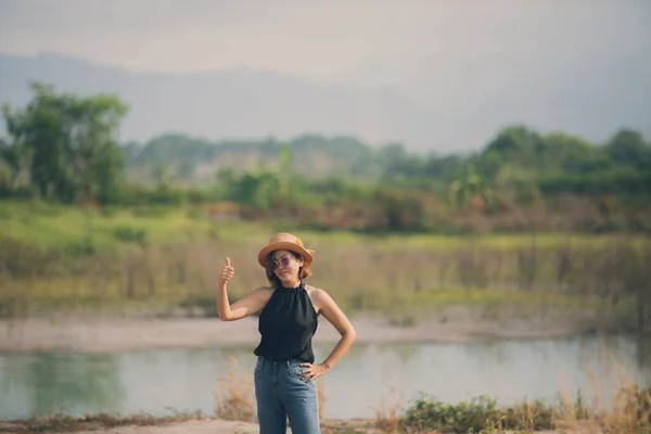 美丽的亚洲女人 站在开阔的土地上 带着好感举起右手大拇指 — 图库照片