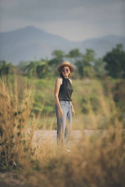幸せそうな顔で笑顔で屋外に立つ藁帽子をかぶったアジアの女性 — ストック写真
