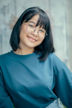 Asyalı bir gencin portresi. Mutluluktan gülümsüyor.