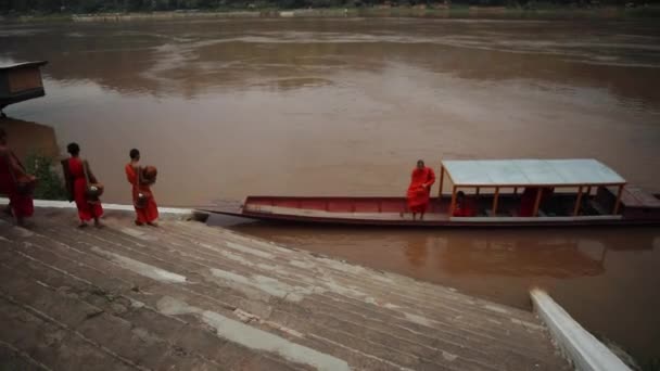ルアンパバーン クライ19 2023 ラオスで最も人気のある旅行先の1つラオスのルアンプラバン北部のメケコン川のそばにモンクと国内のボート — ストック動画
