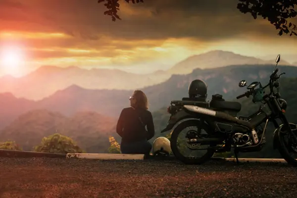Γυναίκα Κάθεται Δίπλα Μοτοσικλέτα Όμορφη Θέα Και Κοιτάζοντας Προς Ηλιοβασίλεμα Εικόνα Αρχείου