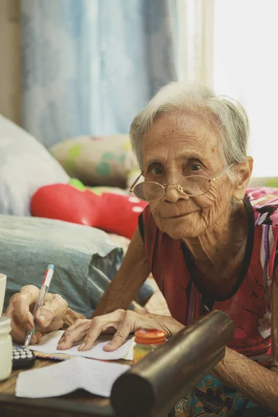 Ηλικιωμένη Ασιάτισσα Που Γράφει Λευκό Χαρτί Στο Σαλόνι Του Σπιτιού Royalty Free Εικόνες Αρχείου