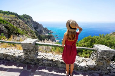 İtalya 'da tatil. Capo Vaticano 'da şapkalı tam teşekküllü genç bir kadın. İtalya, Calabria, tanrıların kıyılarında..