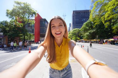 Sao Paulo 'da turizm. Gülümseyen güzel kız Paulista Bulvarı, Sao Paulo, Brezilya 'da kendi portresini çekiyor..