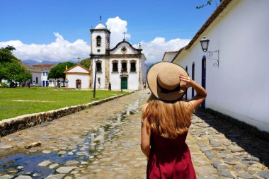 Tourism in Paraty, Brazil. Girl walking in the historic town of Paraty, UNESCO World Heritage Site, Rio de Janeiro, Brazil.