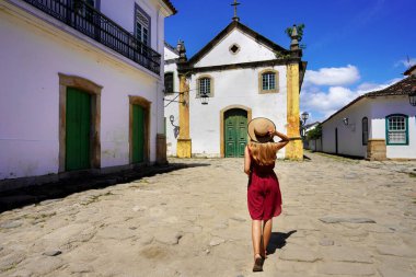 Tourism in Paraty, Rio de Janeiro. Back view of female tourist in the historic colonial town of Paraty, UNESCO World Heritage Site, Rio de Janeiro, Brazil.