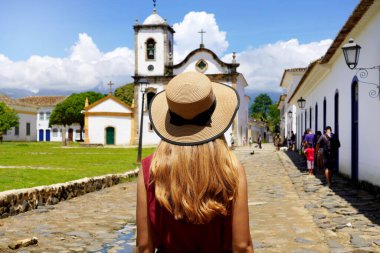 Tourism in Brazil. Young woman visiting the historic town of Paraty UNESCO World Heritage Site, Rio de Janeiro, Brazil.