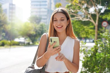 Genç bayan girişimci sabahları modern metropolde yürüyor.
