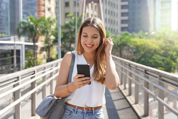Привлекательная Улыбающаяся Женщина Идущая Пешеходному Мосту Проверяет Телефон Современном Устойчивом — стоковое фото