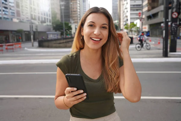 Настоящие Люди Улице Самоуверенная Девушка Телефоном Смотрит Камеру Пустом Мегаполисе — стоковое фото