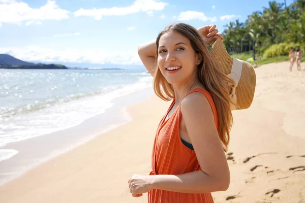 Stock image Portrait of beautiful carefree girl holding straw hat on tropical beach looking away