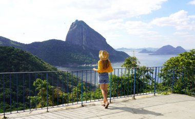 Rio de Janeiro 'da tatiller. Urca Hill 'den Sugarloaf Dağı' na, UNESCO Dünya Mirası 'na Rio de Janeiro, Brezilya' ya giden teleferik arayan gezgin kadınların arka görüntüsü.